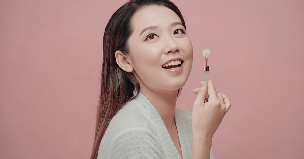 Woman in a white shirt on a pink background smiling