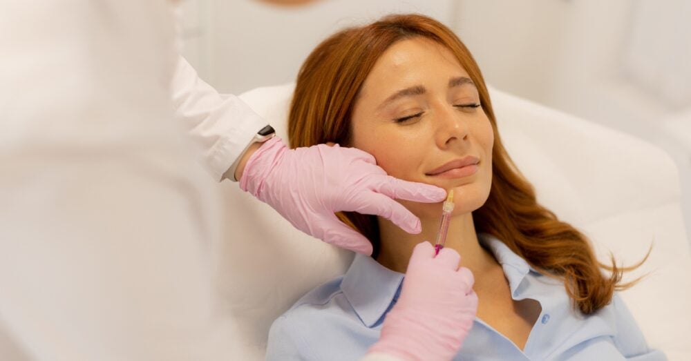 Woman with eyes closed while receiving treatment near her chin