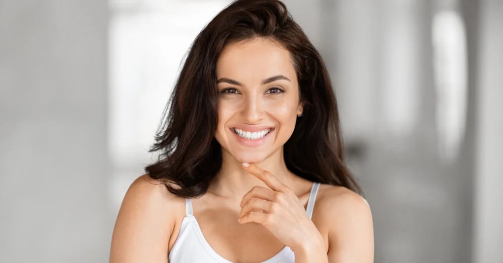 Woman smiling against a neutral background
