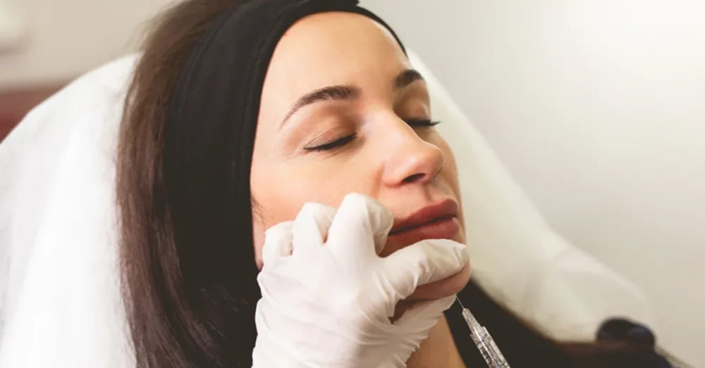 Provider injecting a treatment beneath a patient’s chin