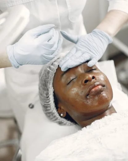 Gloved provider preparing a patient’s face during an in-office treatment